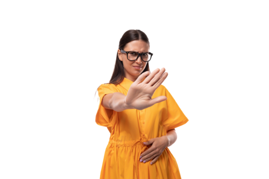 young black-haired woman with glasses dressed in an orange summer dress doubts and is angry