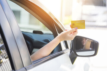 Closed up hand use credit card on car to pay for fuel