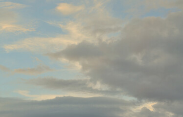 Fototapeta premium A blue cloudy sky with many small clouds blocking the sun