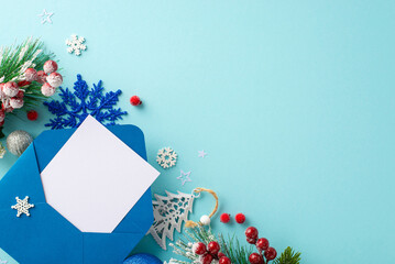 Capture the magic of Christmas. Top view of an envelope with blank paper, baubles, pine branches,...