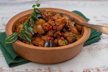 Vegan Indian curry with mock meat eggplant,  seitan, plant based  protein. Served in clay dish.