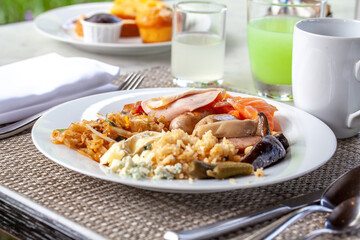 Close-up breakfast plate, variety of warm and cold breakfast items, detailed food presentation, outdoor dining elegance