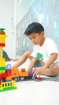 Adorable kindergarten boy enjoying with colorful vehicle toy block building imagination learnning toy