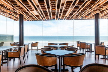 Open concept beach restaurant with wooden architectural details, providing guests with immersive seaside dining experience. Luxury resorts and relaxation.