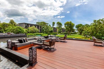 Luxurious outdoor living space with contemporary lounge sofas and scenic water feature in upscale tropical resort. Outdoor living and luxury resorts