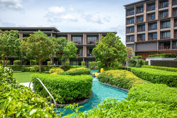 Contemporary hotel design with lush garden pathways and tranquil swimming pool water features in tropical setting