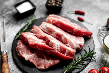raw pork steaks on stone background