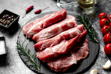 raw pork steaks on stone background