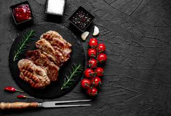 grilled pork steaks on stone background with copy space for your text	