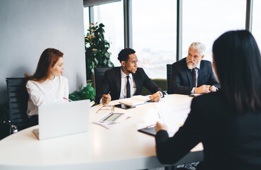 Group of diverse colleagues discussing success of project in office