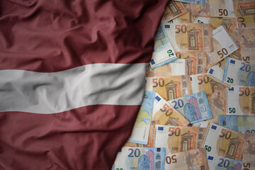 colorful waving national flag of latvia on a euro money background. finance concept