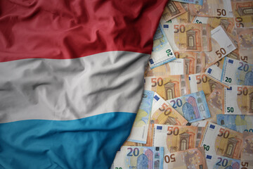 colorful waving national flag of luxembourg on a euro money background. finance concept