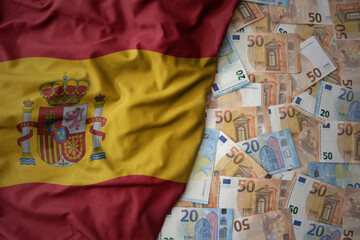 colorful waving national flag of spain on a euro money background. finance concept