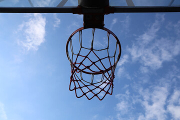 Basketball hoop against blue cloudy sky. Basket ball hoop without ball. low angle view.