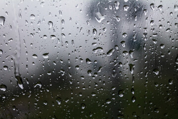 Drops of water on glass on a cold background, rainy weather high humidity, worsening weather forecast selective focus