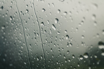 Drops of water on glass on a cold background, rainy weather high humidity, worsening weather forecast selective focus