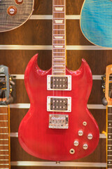 Red electric guitar in a music shop, closeup of photo.