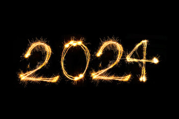 Happy new year 2024 text written with hand drawn golden Sparkle fireworks isolated on black...