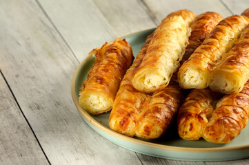 Close-up of puff pastry tubes filled with cottage cheese. Natural lighting, selective focus with copy space