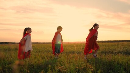Boy girls in red cloak, Child dreams of becoming superhero. Happy girls, boy kids play superheroes...