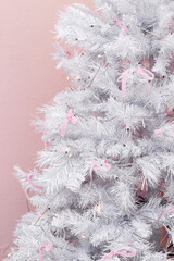 The white Christmas tree is decorated in pink, room decor