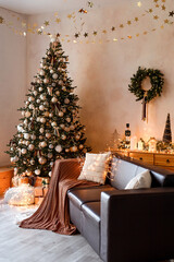 Interior of modern living room with comfortable sofa decorated with Christmas tree and gifts