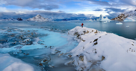 Partly frozen sea and icebergs in Hurry Inlet in Scoresbysund on the east coast of Greenland.