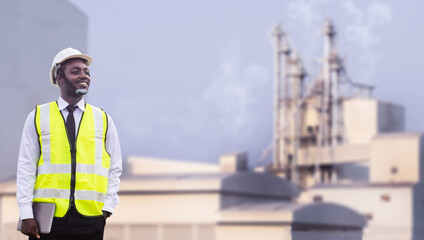 African engineer holding and using tablet works at factory.Engineering for large industry concepts and technological applications © arrowsmith2