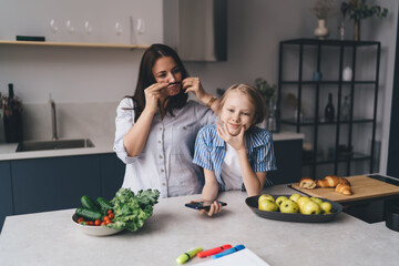 Mother and daughter having fun together in kitchen