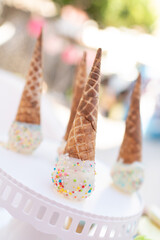 Ice cream cone upside down with frosted sugar and sweet colored sprinkles