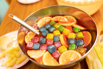 Bowl with fresh fruit juice, with colored ice and orange slices