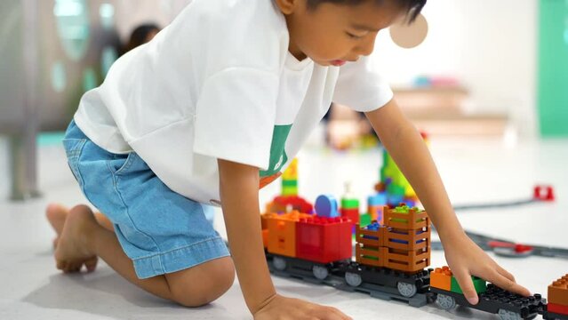 Happy kindergarten kid boy and girl enjoying play building toy block in class imagination learnning concept