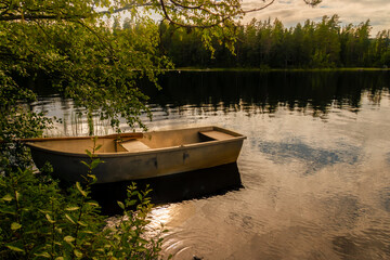 old rowing boat on the shore of a lake at sunset