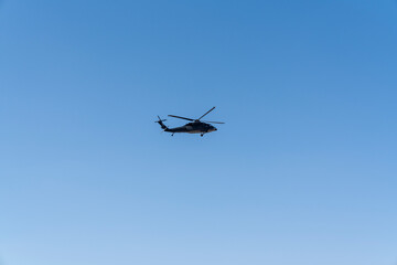A military Sikorsky helicopter flies in the sky