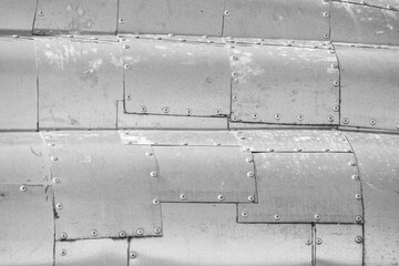 Abstract gray background of riveted aluminum plates. Riveted metal texture