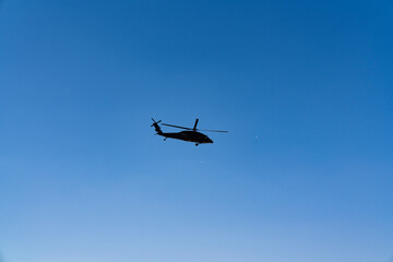A military Sikorsky helicopter flies in the sky