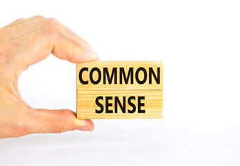 Common sense symbol. Concept words Common sense on beautiful wooden block. Beautiful white table white background. Businessman hand. Business, motivational common sense concept. Copy space.