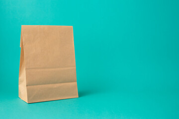 Recycled paper bag on a turquoise background. Copy space