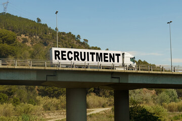 A truck is driving across the bridge, with the inscription on the trailer - RECRUITMENT.