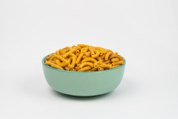 pasta horns in a green bowl on a white background