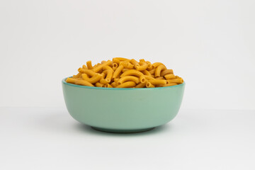 pasta horns in a green bowl on a white background