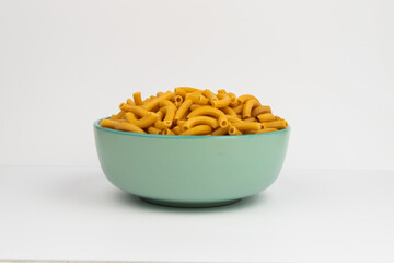 pasta horns in a green bowl on a white background