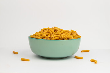 pasta horns in a green bowl on a white background