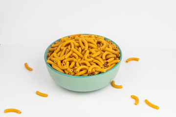 pasta horns in a green bowl on a white background