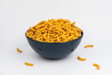 pasta horns in a deep blue bowl on a white background