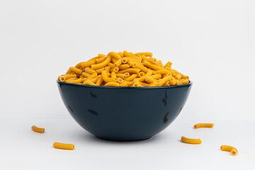 pasta horns in a deep blue bowl on a white background