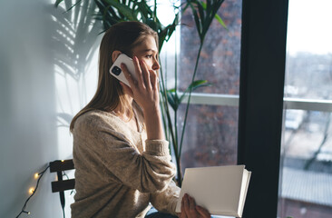 Young woman talking on smartphone while working in office