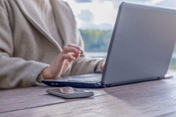The girl works on a laptop in the park at the table