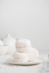 White fluffy marshmallows or marshmallow shells with powdered sugar sprinkles