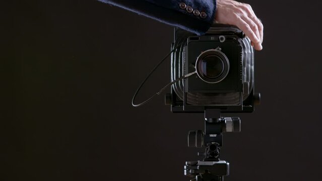 Professional gimbal camera. Cock the shutter in the compur lens and press the shutter using a cable. Screensaver for photo courses. Photographer and analog film camera.